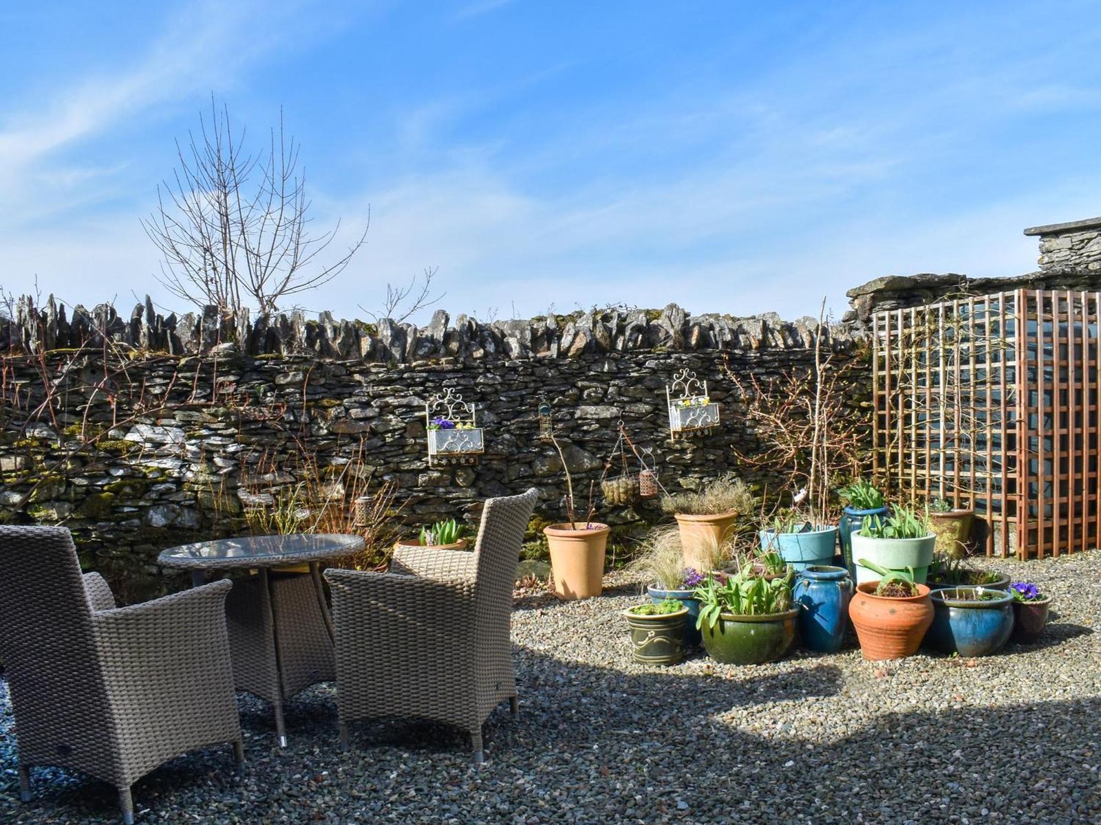 The courtyard at Lickbarrow Lodge with stone walls and garden pots